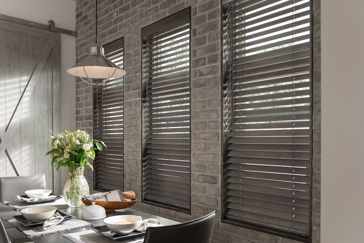 Wood blinds in a sunlit dining area by Desert Window Wear
